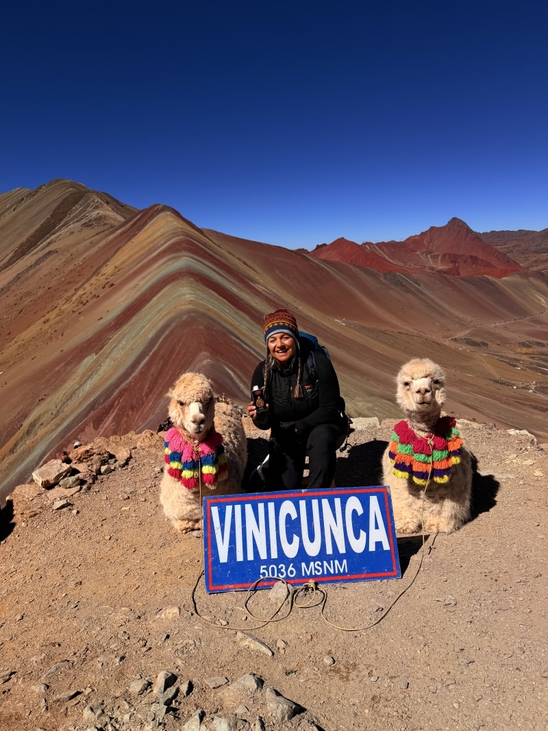 Traveler with llamas at Peru’s colorful Rainbow Mountain
