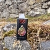 Buriti oil bottle beside mossy rocks and flowing water