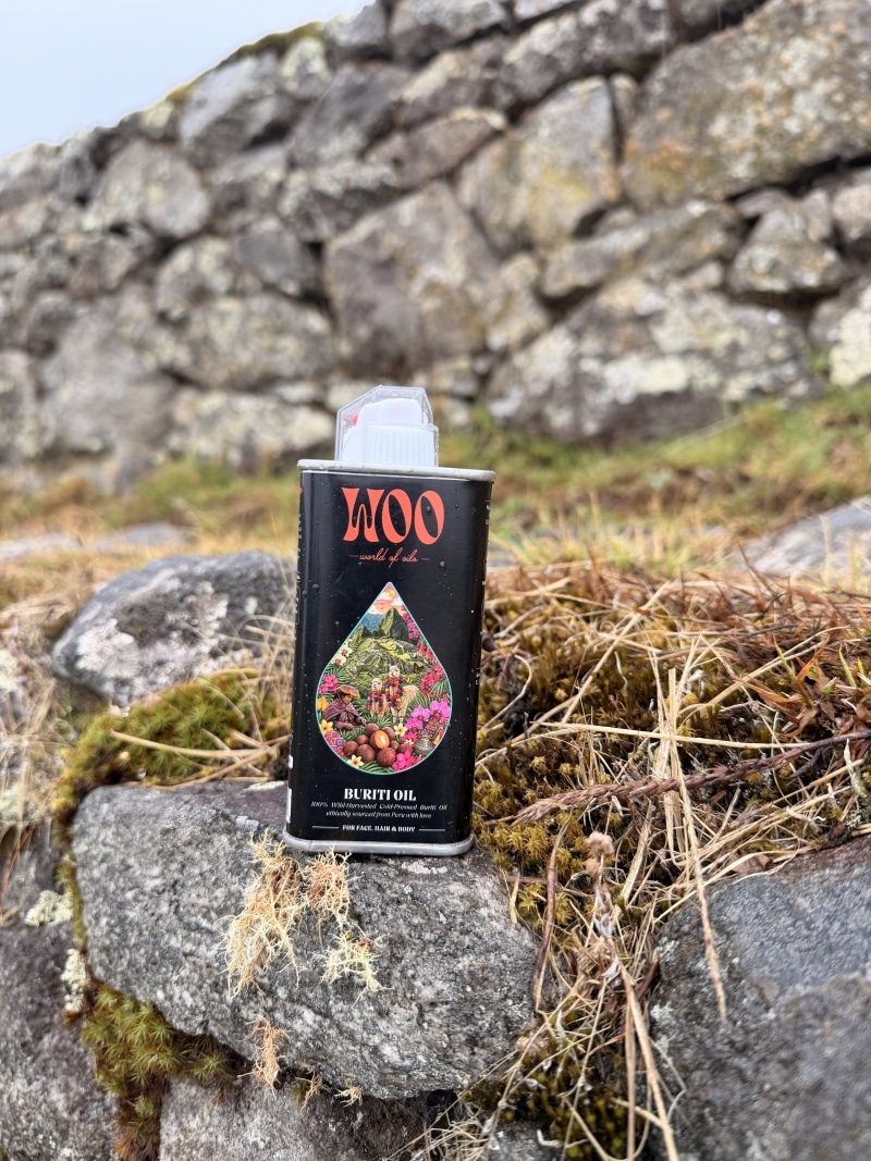 Buriti oil bottle beside mossy rocks and flowing water