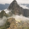 Machu Picchu ruins beneath misty Andes mountains