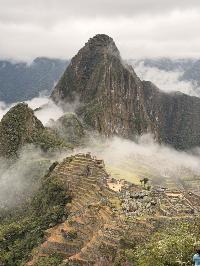 Machu Picchu ruins beneath misty Andes mountains
